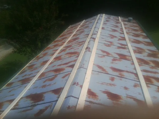 Rusted metal roof panels with new wood purlins before replacement — Storm Damage Roof Repair in Glade Park by Roofing Brothers